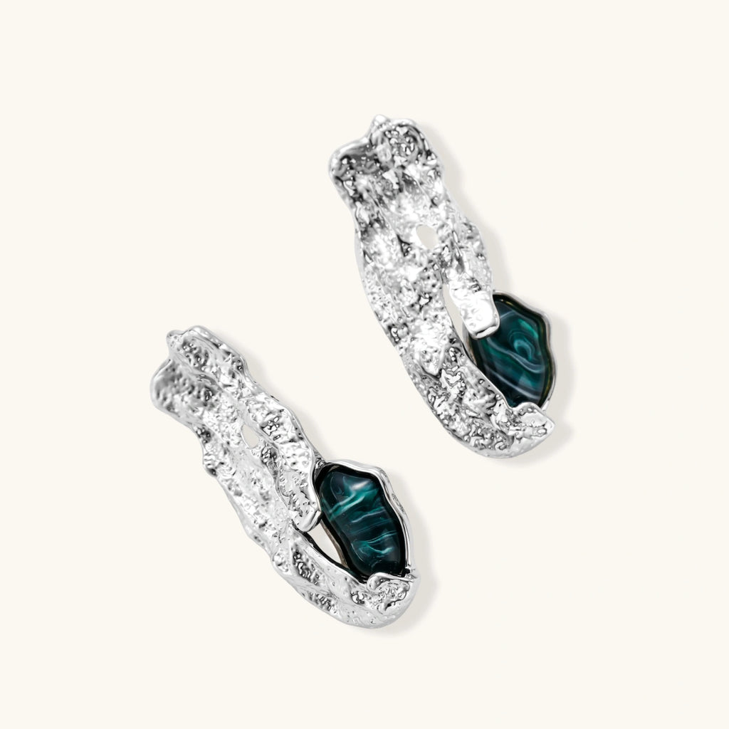 Organic-shaped stud earrings with hammered silver finish and green malachite-pattern resin stones on white background.